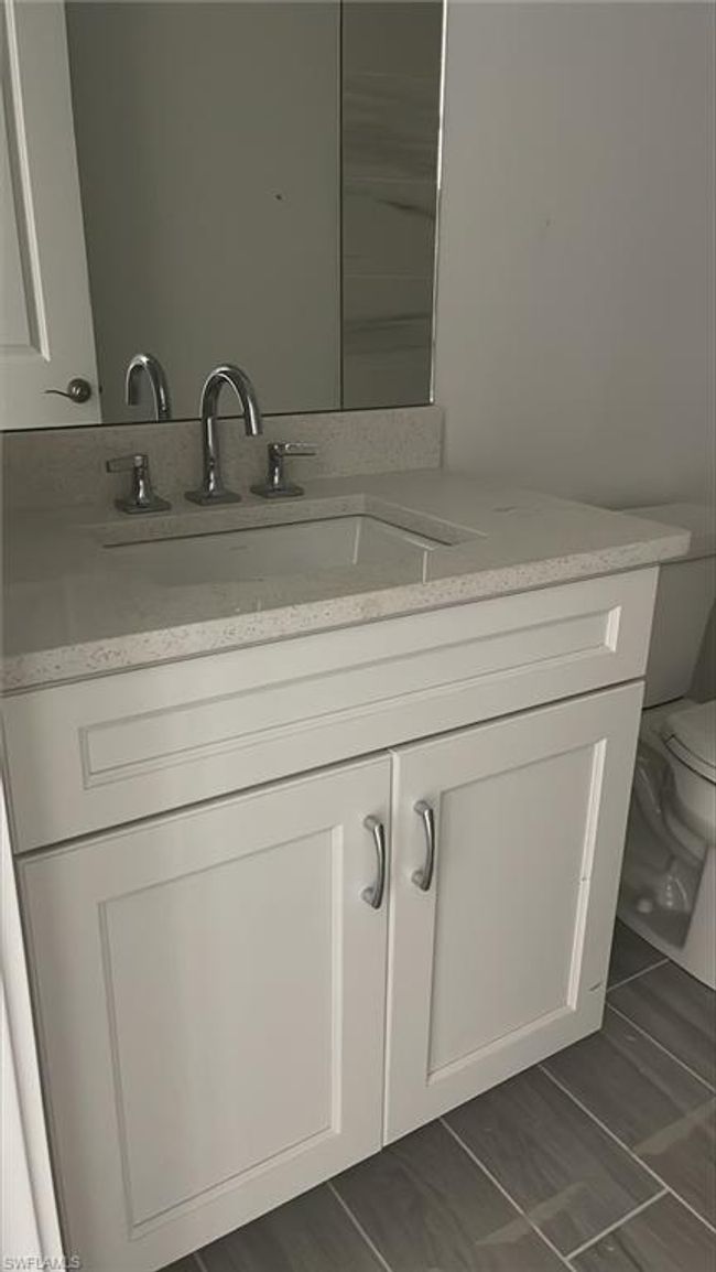 Guest bathroom with lovely quartz countertops and soft-close cabinets | Image 9