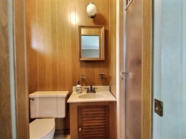 Bathroom with toilet, vanity, and a shower with door | Image 17