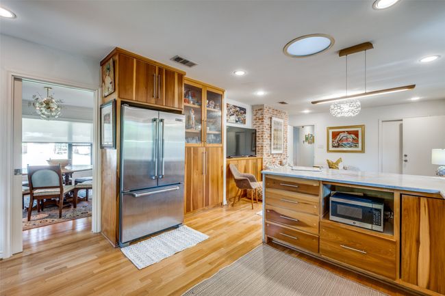 Kitchen featuring pendant lighting, light hardwood / wood-style floors, and appliances with stainless steel finishes | Image 12