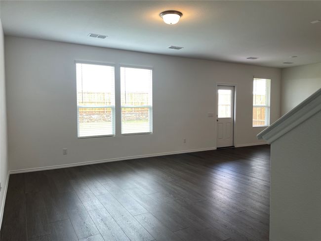 Spare room featuring baseboards, dark wood finished floors, and stairway | Image 10