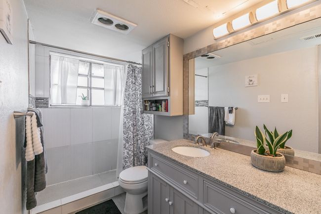 Bathroom featuring toilet, tile patterned floors, a shower with curtain, and vanity | Image 11