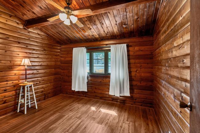 Bedroom featuring wood finished floors, wooden ceiling, and ceiling fan | Image 16