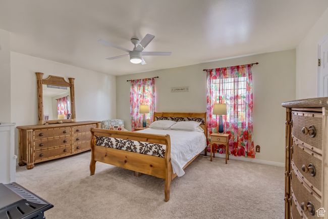 Bedroom featuring baseboards, carpet flooring, a ceiling fan, and multiple windows | Image 25