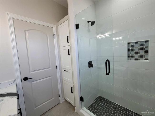 Bathroom with a shower with door and tile patterned flooring | Image 21