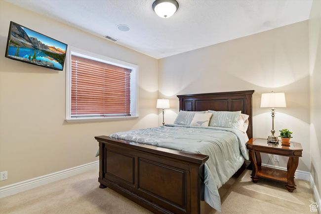 Bedroom featuring baseboards, visible vents, and light colored carpet | Image 42