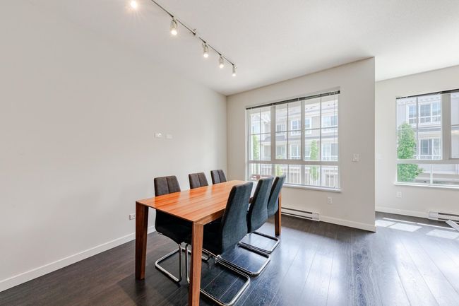 Dining area with a baseboard heating unit, rail lighting, and dark wood-style flooring | Image 9