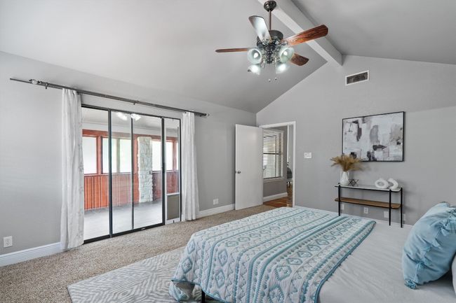 Bedroom with access to exterior, beam ceiling, carpet, ceiling fan, and high vaulted ceiling | Image 15