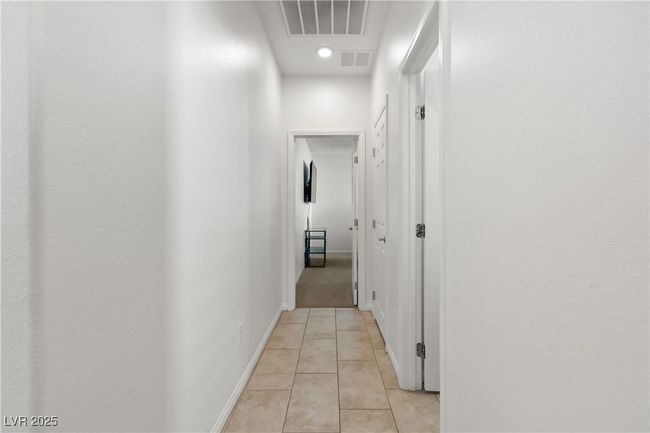 Hall featuring baseboards, visible vents, and light tile patterned flooring | Image 33