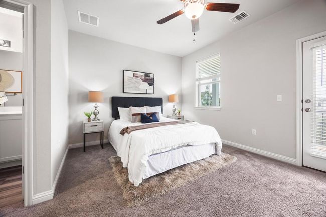 Carpeted bedroom featuring baseboards, ceiling fan, and connected bathroom | Image 8