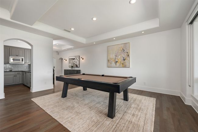 Recreation room featuring a raised ceiling, pool table, ornamental molding, arched walkways, and baseboards | Image 18