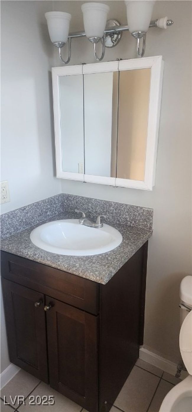Bathroom featuring toilet, vanity, tile patterned floors, and baseboards | Image 4