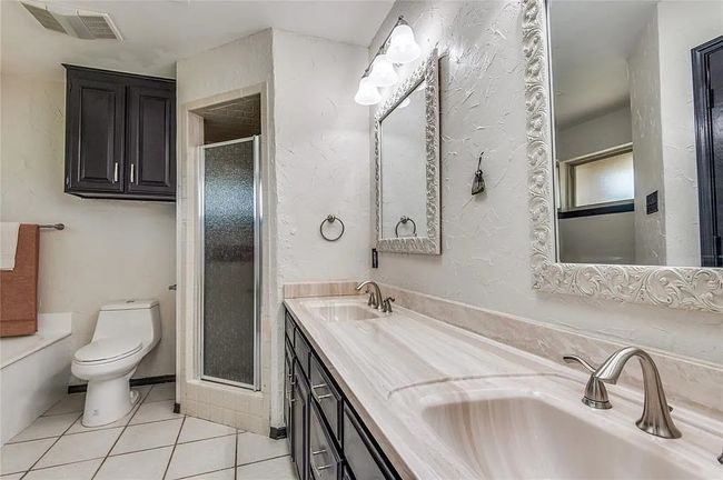 Bathroom featuring visible vents, a sink, toilet, and tile patterned floors | Image 6