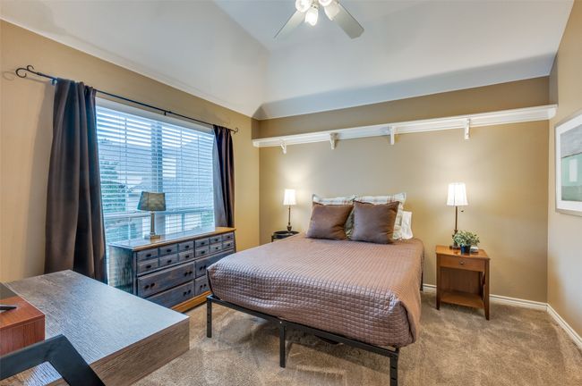 Bedroom featuring light carpet, baseboards, a ceiling fan, and vaulted ceiling | Image 14