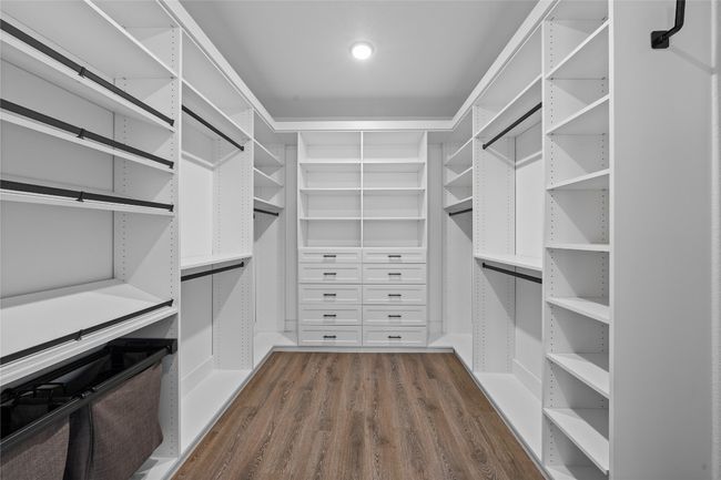 Walk in closet featuring dark wood-style floors | Image 12