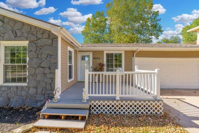 Doorway to property featuring covered porch and a garage | Image 2