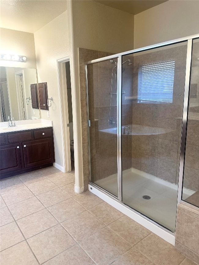 Bathroom with tile patterned floors, vanity, and a stall shower | Image 16