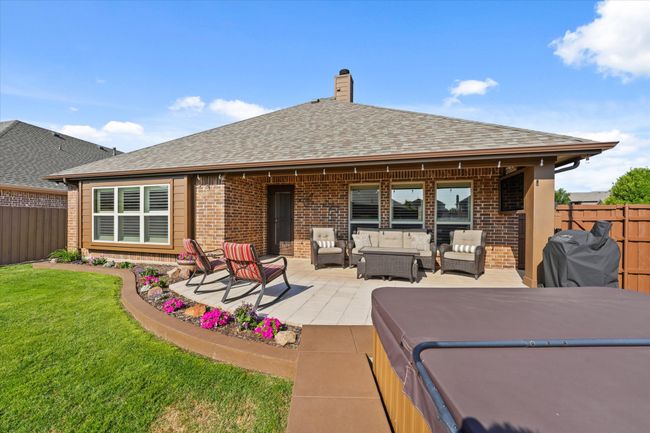 Back of house with brick siding, an outdoor hangout area, a shingled roof, and fence | Image 36