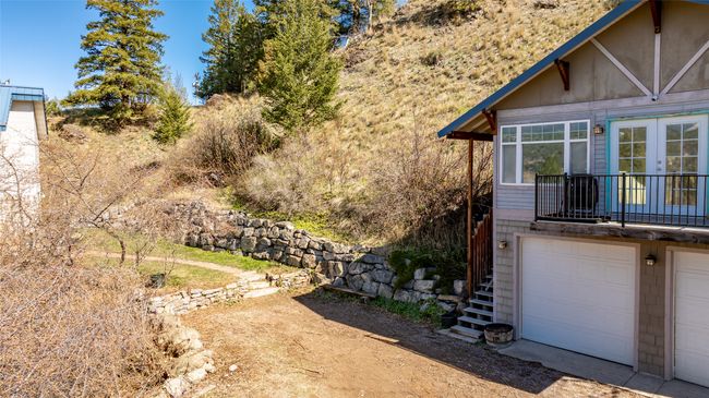 View of side of home with stairway, a garage, and french doors | Image 52