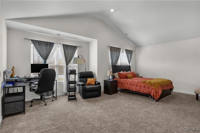 Bedroom featuring baseboards, carpet floors, vaulted ceiling, and multiple windows | Image 11