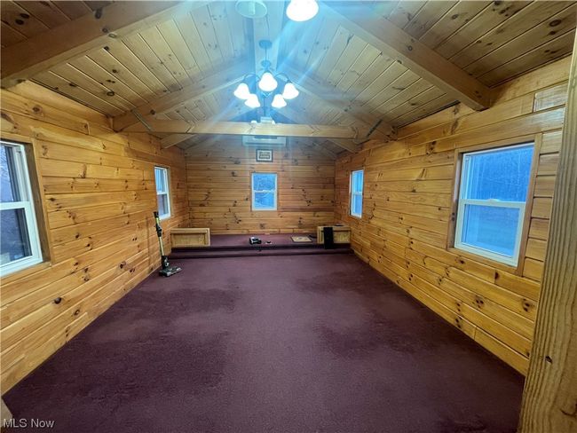 Bonus room featuring wood walls, wooden ceiling, lofted ceiling with beams, and carpet flooring | Image 34