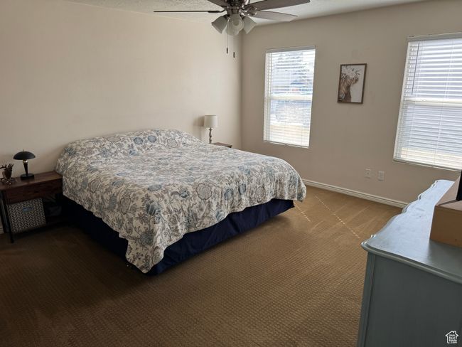 Bedroom featuring baseboards, ceiling fan, and dark carpet | Image 8