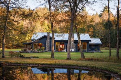 View of side of house with a pond, lawn | Image 2