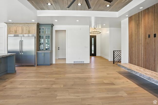 Kitchen featuring stainless steel built in fridge, recessed lighting, light wood finished floors, ceiling fan, and glass insert cabinets | Image 17