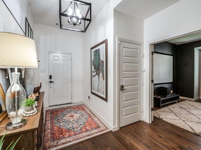 Entryway with a notable chandelier, baseboards, and dark wood-style flooring | Image 4