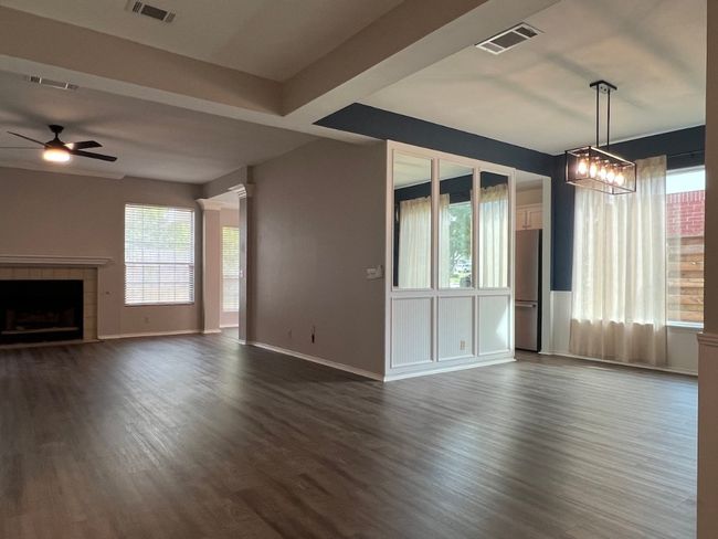 Unfurnished living room featuring dark wood-type flooring, a fireplace, and a ceiling fan | Image 7