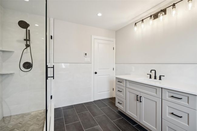 Full bathroom with a stall shower, vanity, tile walls, recessed lighting, and tile patterned flooring | Image 17