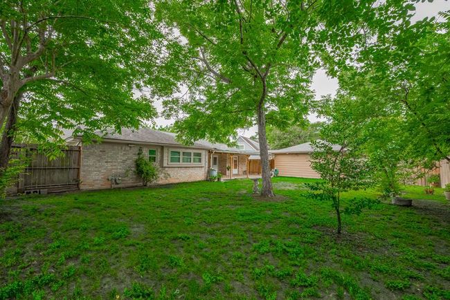 Spacious backyard with lush greenery and mature trees, offering a serene outdoor space. | Image 41