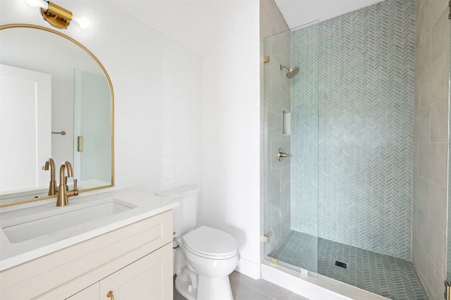 Full bath featuring a shower stall, toilet, tile patterned floors, and vanity | Image 21