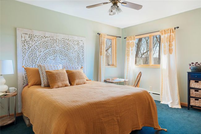 Carpeted bedroom featuring baseboards, a baseboard heating unit, and a ceiling fan | Image 20