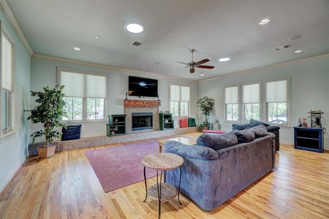 Living area with ceiling fan, baseboards, ornamental molding, and visible vents | Image 7
