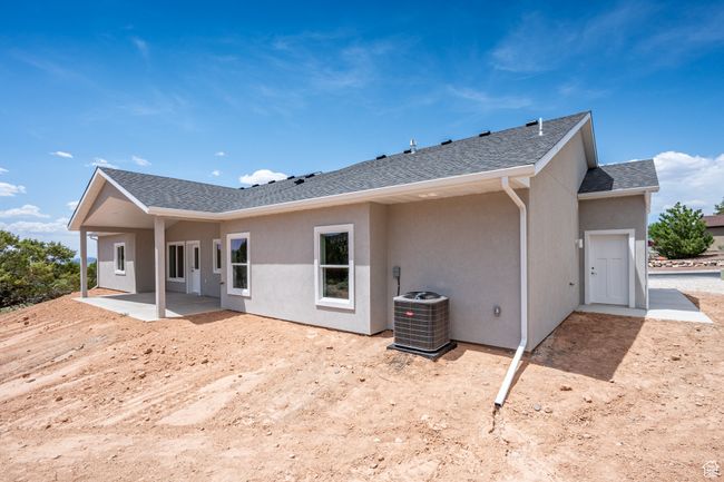Back of house with a patio, central air condition unit, stucco siding, and roof with shingles | Image 52
