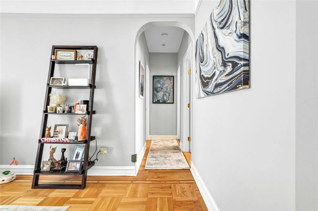 Hall with baseboards and arched walkways | Image 17
