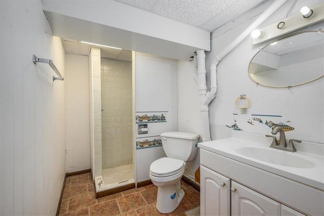 Bathroom with vanity, toilet, tiled shower, and a drop ceiling | Image 28