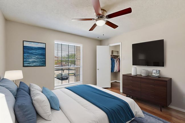 Bedroom featuring wood finished floors, a textured ceiling, a spacious closet, and a ceiling fan | Image 21