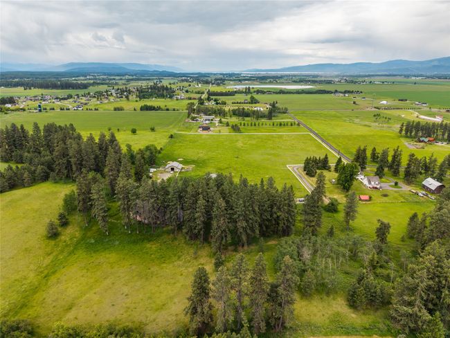 Aerial view of sparsely populated area featuring a mountain backdrop and agricultural land | Image 54
