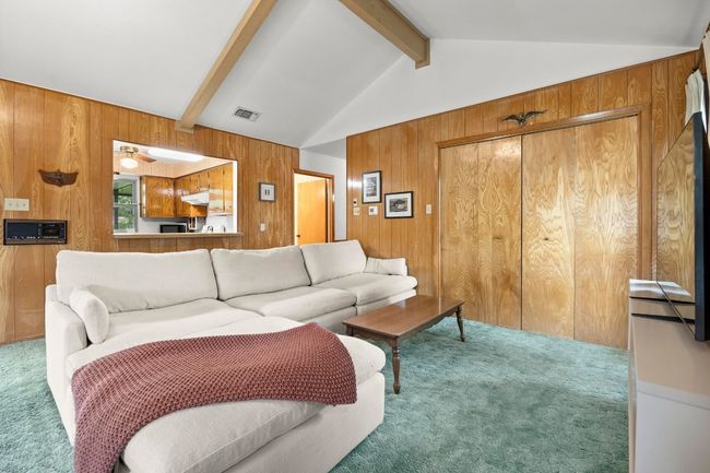 Living area featuring carpet floors and wooden walls | Image 8