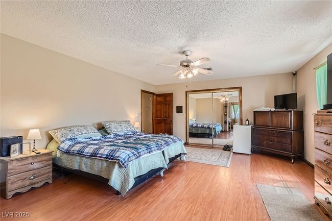 Bedroom with light wood-type flooring, a textured ceiling, a ceiling fan, and a closet | Image 17