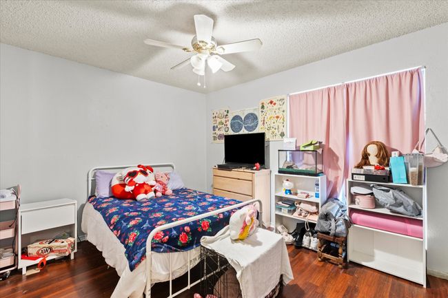 Bedroom with wood finished floors, a textured ceiling, and ceiling fan | Image 10