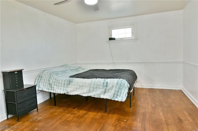Bedroom featuring wood-type flooring, a ceiling fan, and baseboards | Image 36