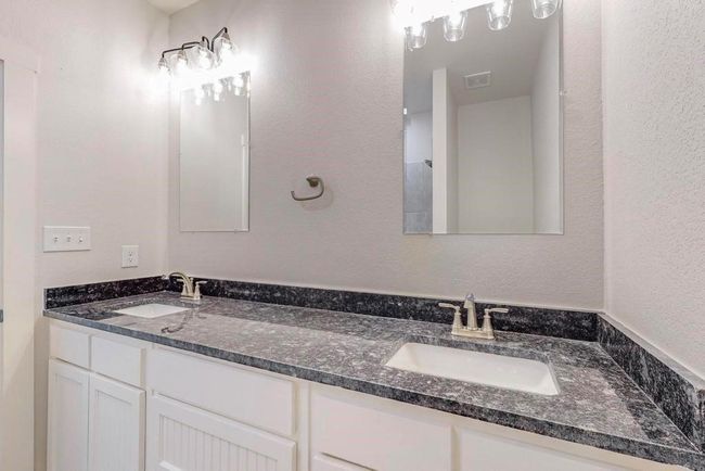 Bathroom with double vanity, a sink, and visible vents | Image 13