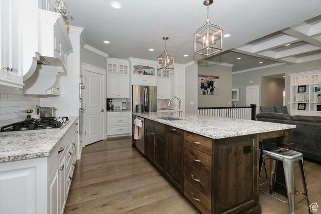 Kitchen with white cabinets, a sink, tasteful backsplash, appliances with stainless steel finishes, and a notable chandelier | Image 32
