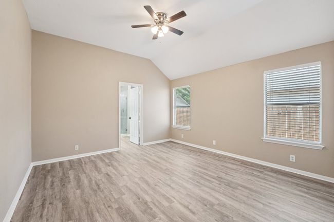 Unfurnished room with light wood-style floors, vaulted ceiling, and a ceiling fan | Image 17