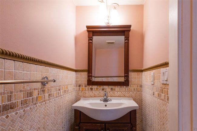 Half bathroom featuring tile walls, a wainscoted wall, and vanity | Image 10