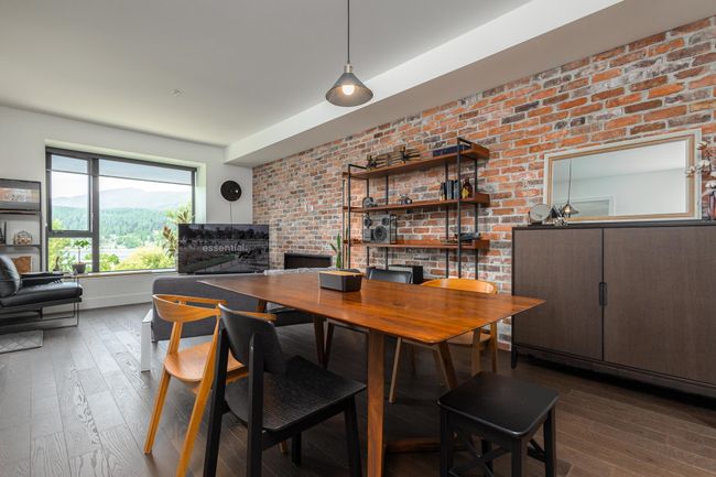 Dining space featuring wood-type flooring and brick wall | Image 11