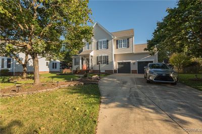 View of front of house featuring a front yard and a garage | Image 1