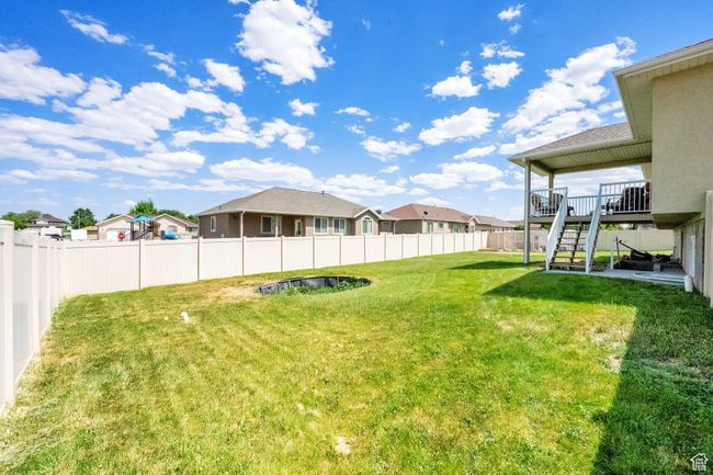 Fenced backyard with stairs, a residential view, and a wooden deck | Image 25